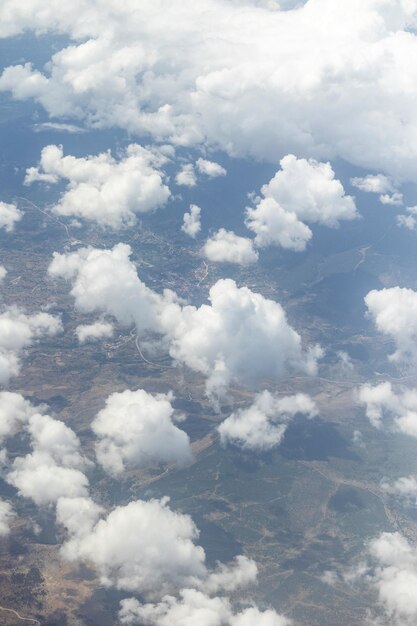 View from the airplane window clouds land and sky