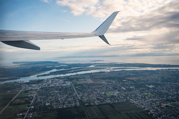 混雑したダウンタウンとカナダのトロントの海につながる大きな川のある飛行機からの眺め