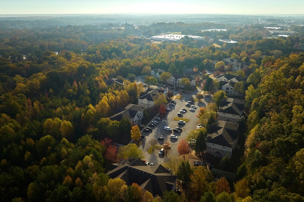 View from above of apartment residential condos between yellow fall trees in suburban area in South Carolina American homes as example of real estate development in US suburbs