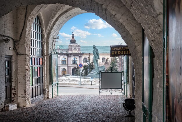 View from the arch of the exit from the Kazan Kremlin to the National Museum of Tatarstan and the monument to Musa Jalil. Caption: Kremlin souvenirs