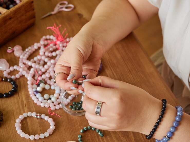 上からの眺め職人の女性は、自宅の工房で宝石からジュエリービーズを作成します。