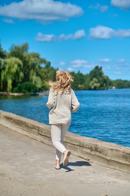 海の近くで走っている女性の後ろからの眺め