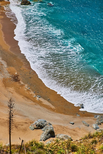 View from above of beach with beautiful blue ocean waves crashing