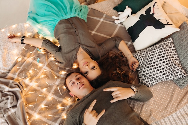 Photo view from above of beautiful woman and handsome man lying on bed