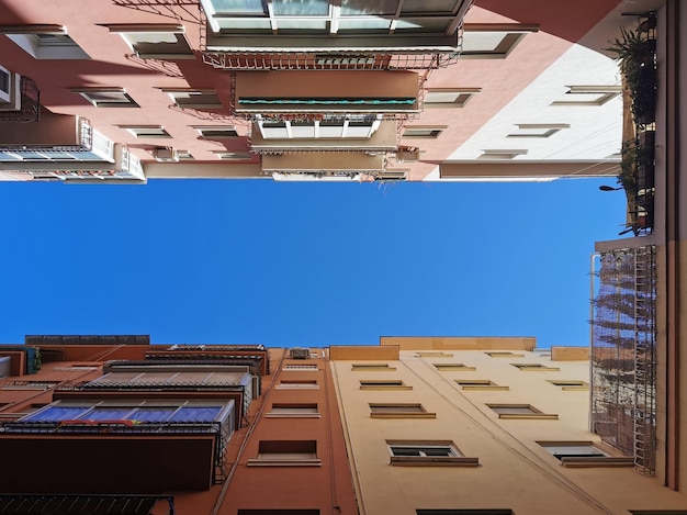 Вид снизу на голубое небо между зданиями в Малаге