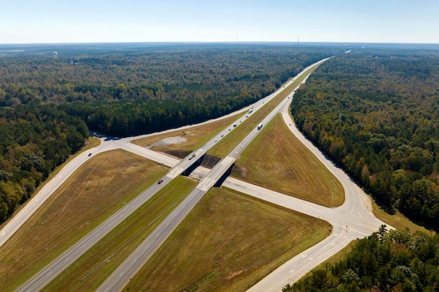 Вид сверху на оживленное американское шоссе с быстро движущимся движением между лесами Концепция межгосударственного транспорта