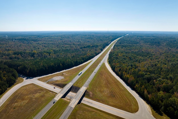 Photo view from above of busy american highway with fast moving traffic between woods interstate transportation concept