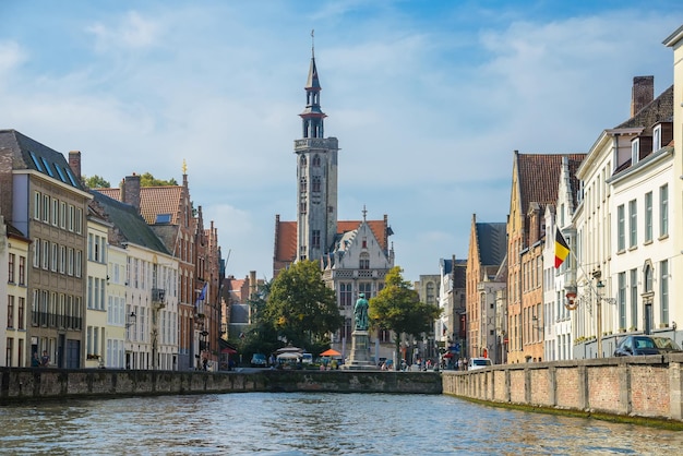 View from the canal to old medieval houses cathedral church and Square Jan van Eyckplein in Bruges Belgium