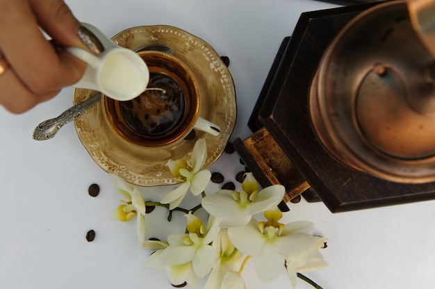 View from above on the cup of coffee in which pouring milk on the white table