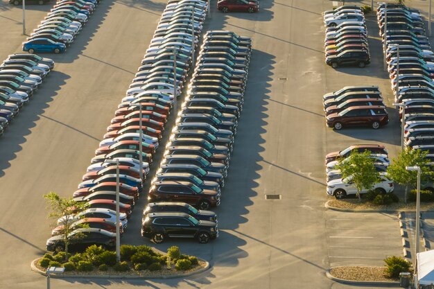 Photo view from above of dealers outdoor parking lot with many brand new cars in stock for sale concept of development of american automotive industry