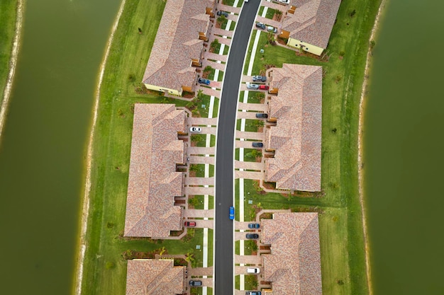 View from above of densely built residential houses near retention ponds in closed living clubs in south Florida American dream homes as example of real estate development in US suburbs