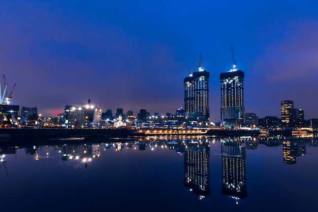 View from the embankment of high skyscrapers reflected in the water