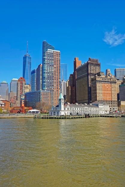 Vista dal traghetto sul molo a a battery park a lower manhattan di new york, stati uniti. fiume hudson. turisti nel parco.