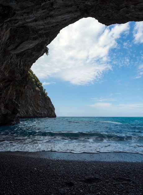 View from the grotto to the beach on a sunny day in the Aegean Sea on the island of Evia in Greece