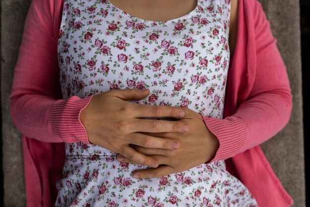 View from above of the hands of young Latin American woman 33 She is wearing a flowered dress and a pink sweater Not recognizable Spring concept