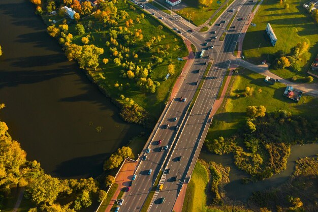 View from the height of the road with cars near the autumn Park