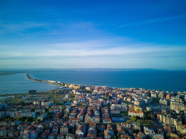 Вид с высоты над городом Поморие с домами и улицами, омываемыми Черным морем в Болгарии.