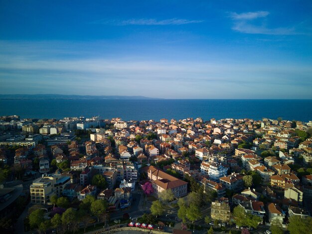 Вид с высоты над городом Поморие с домами и улицами, омываемыми Черным морем в Болгарии.