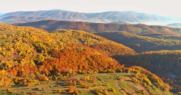 A view from a height of a yellow forest mountain valley surrounded by high mountains