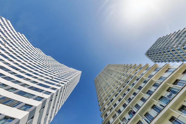 Foto vista da sotto nel cielo blu con le nuvole di un grande complesso residenziale moderno a grattacieli