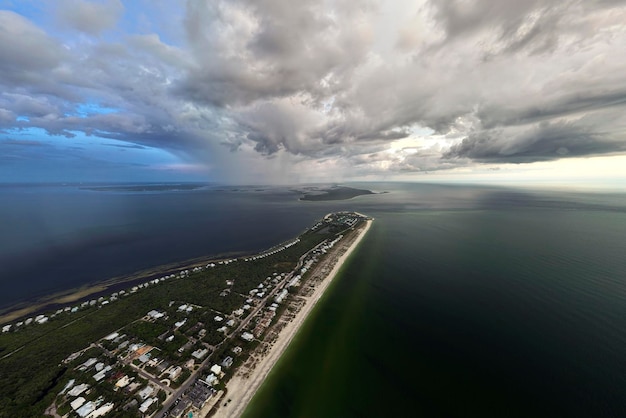 View from above of large storm approaching over residential houses in island small town Boca Grande on Gasparilla Island in southwest Florida Climate change concept