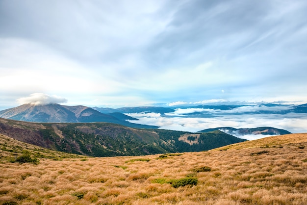 View from the mountain to beautiful landscape with grass and blue clouds.