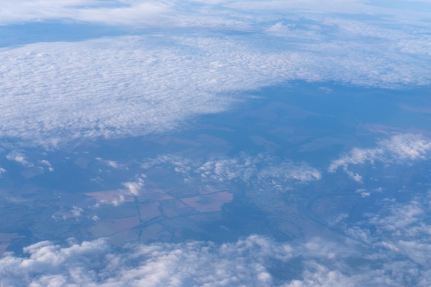 The view from the plane window to the clouds and the ground The landscape of the earth's surface