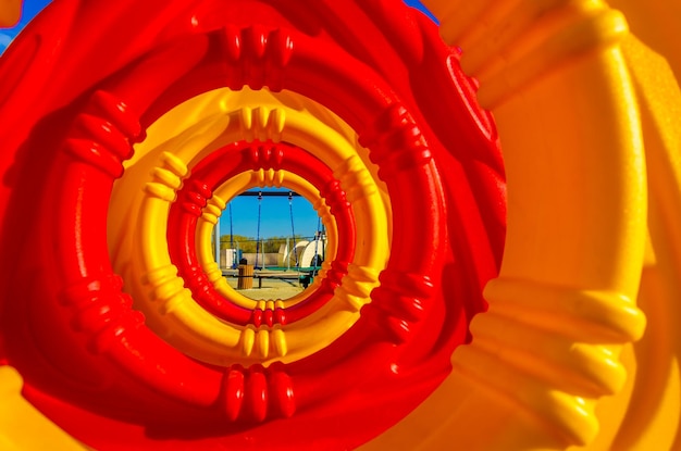 Foto vista da un tubo di plastica nel parco giochi.