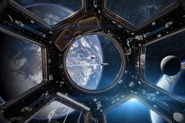 View from a porthole of space station on the Earth background