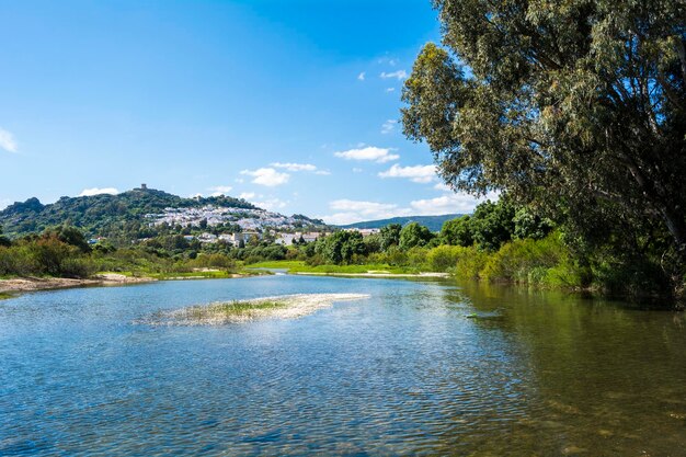 View from the river of a mountain village with a castle on top