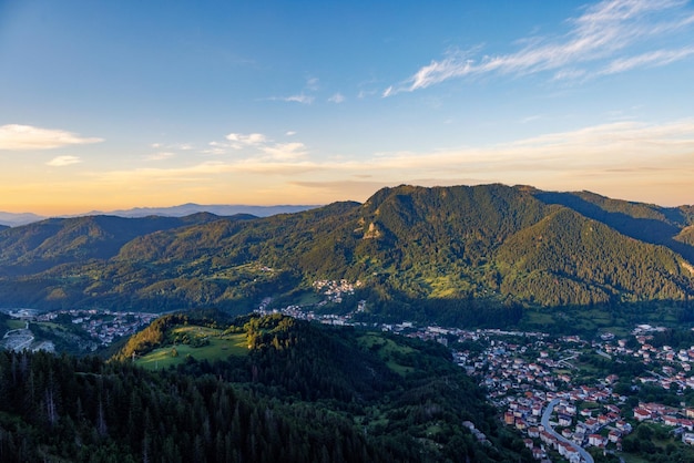 View from rock to town of smolyan with meadows for cattle walking and houses between mountain range