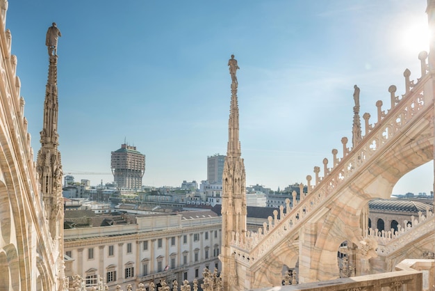 View from roof of Duomo to spires with statues and sity of Milan with tower Torre Velasca. Italy