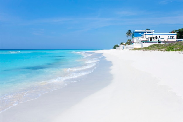 View from the shore of a paradisiacal beach in Varadero with crystal clear waters, white sand and blue sky.