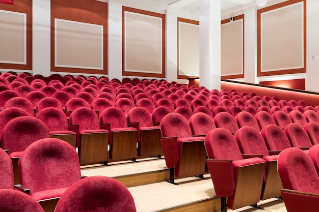 View from stairs on rows of comfortable red chairs in theater 