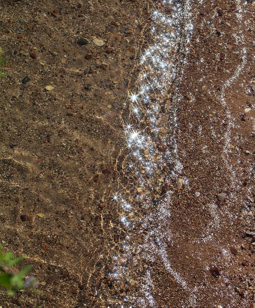 View from above to a stony seabed crystal clear water on the\
surface of a sea overview of the seabed seen from above transparent\
sparkling water reflects the sunlight red sea in eilat israel