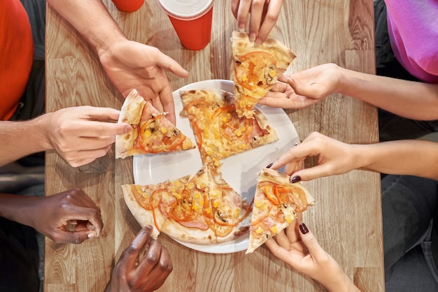 View from above of tasty pizza lying on plate in cafe