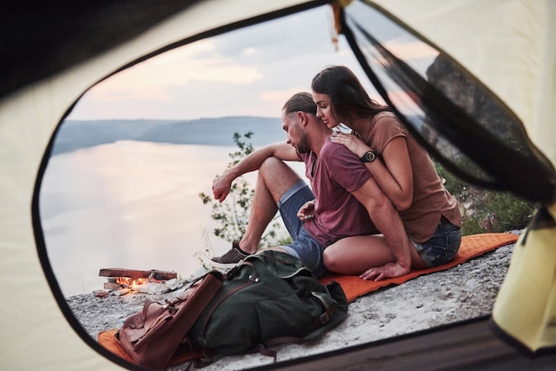ハイキング旅行中に湖の景色を横になっているカップルのテントからの眺め。 avelライフスタイルコンセプトアドベンチャーバケーションアウトドア