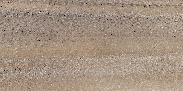 Photo view from above on texture of gravel road with car tire tracks