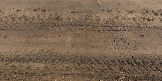 View from above on texture of gravel road with car tire tracks