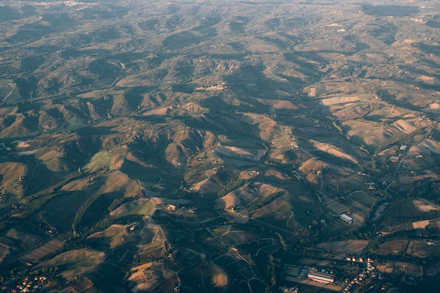 写真 トスカーナの山々の飛行機の窓からの眺め