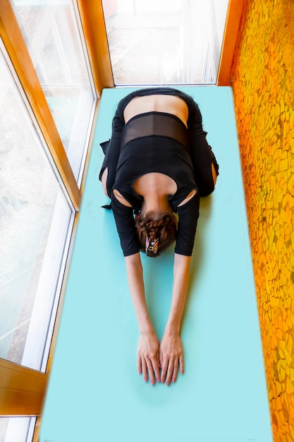 View from top of a woman stretching on yoga mat