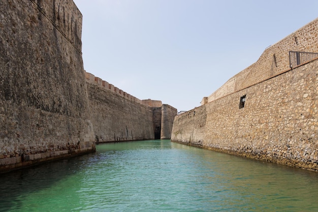 Vista da una barca turistica delle mura reali di ceuta e del suo fossato navigabile