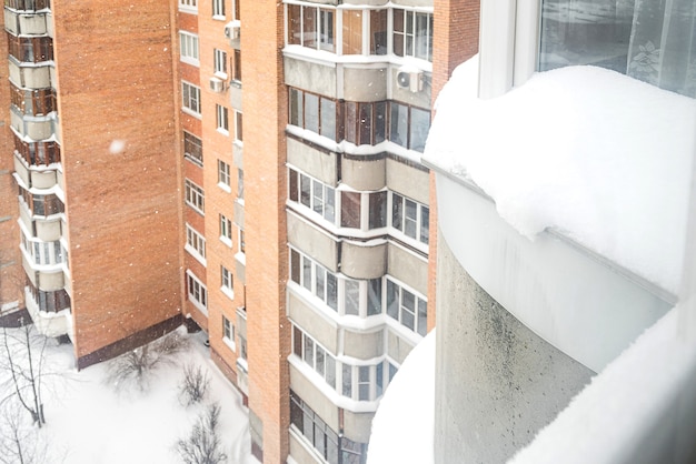 冬の雪に覆われた中庭の高層ビルの窓からの眺め