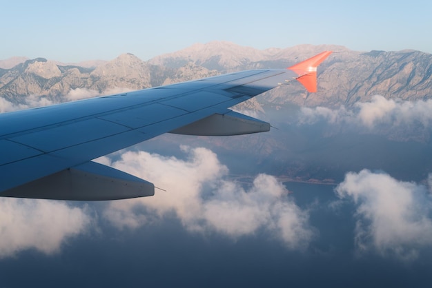 View from the window of the plane to the mountains and clouds