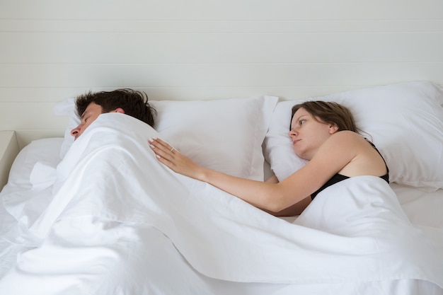 View from above on the young couple sleeping in their bed in the morning