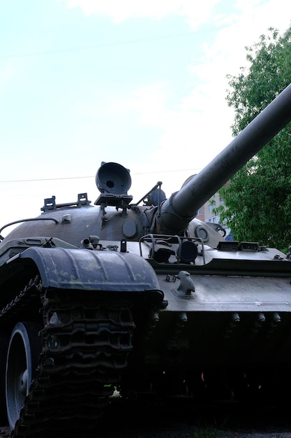 Photo view of the front part of the green caterpillar of the tank standing on the ground with the wheels