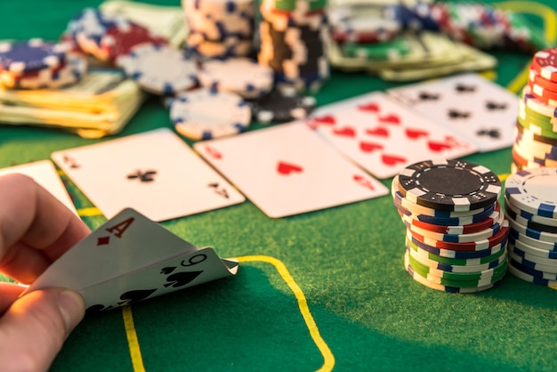 Vista di un tavolo da gioco con molte carte da poker e fiches tappetino verde. gioco del casinò