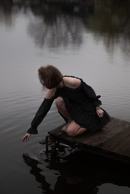 Photo view of a girl in dress near lake