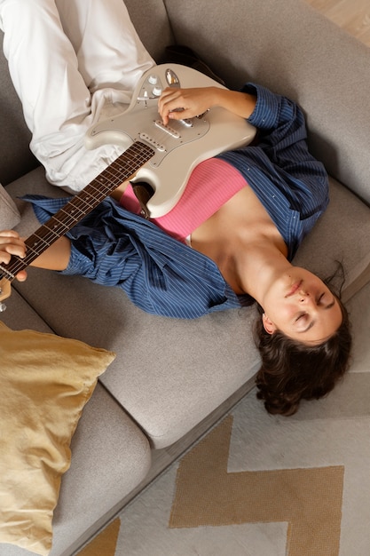 Photo above view girl playing the guitar at home