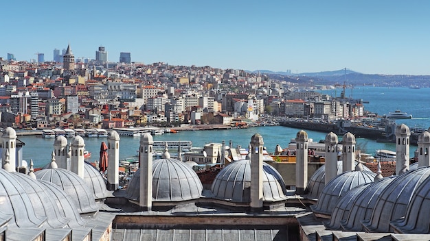 Photo view over the golden horn or bosphorus strait of istanbul city through cupolas domes.